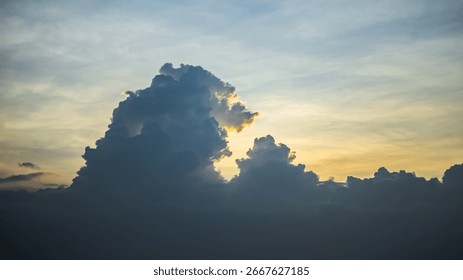 Dramatic cloudscape with sunlight glowing behind thick clouds during golden hour, natural sky background for weather and nature themes.