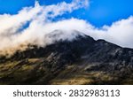 Dramatic cloudscape at sunrise over the glacial rock peaks of Chugach Mountains in Anchorage, Alaska, a summer morning landscape view from Glen Alps Hiking Trail