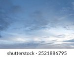 Dramatic cloudscape of white fluffy clouds against a deep blue sky, illuminated by the warm light of the setting sun