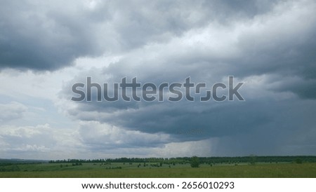 The Dramatic Cloudy Skies That Sweep Over the Expansive Green Landscape Below Them