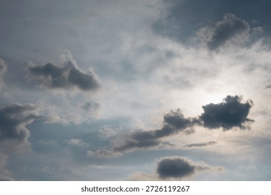 Dramatic cloudy sky background with sun hiding behind dark clouds