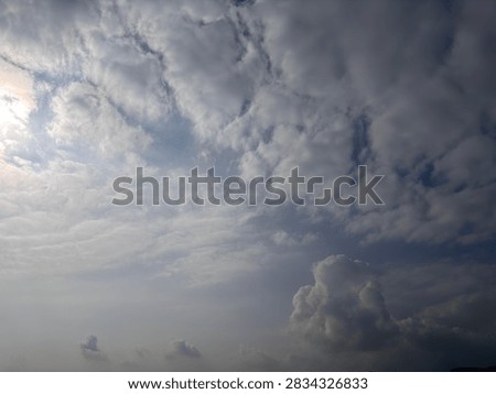 Dramatic cloudy sky background with sunlight piercing through thick clouds. Natural weather landscape and atmospheric skyscape photography.