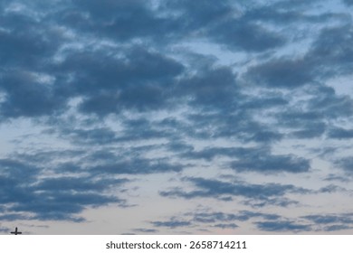 Dramatic cloudy sky with layered storm clouds creating moody atmospheric conditions during golden hour lighting