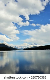 Dramatic Cloudy sky over Canadian Rockies reflected in Maligne Lake