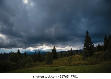 Dramatic cloudy sky over a forest landscape with trees and hills.