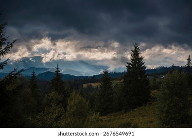 Dramatic cloudy sky over a forested mountain landscape.