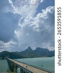 Dramatic cloudy sky over a mountain bridge crossing lake in Spain