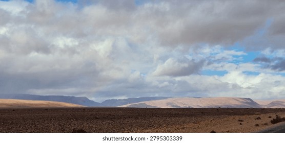 Dramatic Cloudy Sky Over Vast Rocky Desert Plain

