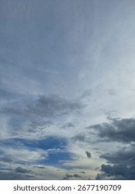Dramatic cloudy sky with patches of blue and soft light, creating a natural abstract pattern in the atmosphere.