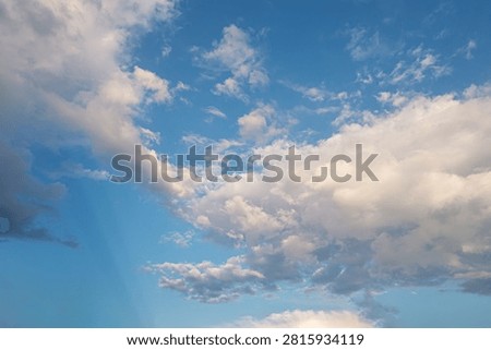 Dramatic cloudy sky with soft natural light and blue background. Volumetric white clouds forming abstract shapes, suitable for weather concepts, nature themes, and background design.