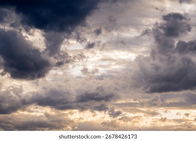 Dramatic cloudy sky with sun rays through dark and yellow clouds