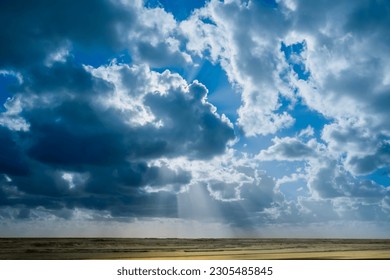 Dramatic cloudy sky and suns rays over sea  at Bayleys beach in Northland, New Zealand.
