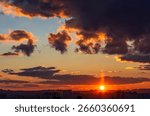 Dramatic cloudy sky at sunset over city skyline