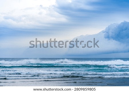 Dramatic cloudy storm above sea waves on Allans Beach, Otago, South Island, New Zealand