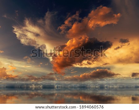 dramatic cloudy  sunset ,sun beams on blue pink sky yellow clouds skyline, water sea reflection beautiful landscape summer nature