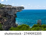 Dramatic coastal cliffs and deep blue ocean along the Eagle Rock coastal walk in Royal National Park, New South Wales, Australia.