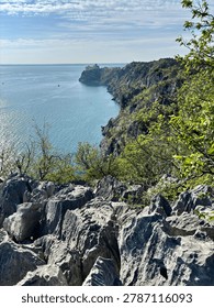 Dramatic coastal cliffs dropping vertically into the deep blue ocean water