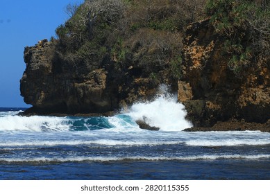 Dramatic Coastal Cliffs, Rocky Shore, and Small Island with Blue Ocean Waves, Indonesia

A breathtaking coastal landscape featuring towering cliffs, rugged rock formations, and a small offshore island surrounded by the crystal-clear blue waters of the Indian Ocean. Powerful waves crash against the rocky shoreline, creating a dramatic tropical seascape that showcases the untouched beauty of Indonesia's coastline. Ideal for travel, tourism, nature, adventure, geology, marine, and coastal landscape themes.
