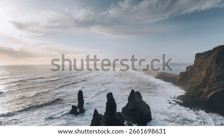 Dramatic coastal landscape with rugged cliffs and crashing waves. Coastal beauty with cliffs and waves. Rugged cliffs, ocean waves, and misty skies create a stunning scene. Iceland nature and travel.