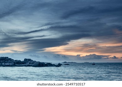 Dramatic coastal seascape with a breathtaking sunset, featuring rocky shores and a serene ocean - Powered by Shutterstock