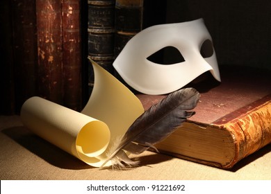 Dramatic concept. Vintage still life with quill and scroll near mask and old books on dark background
