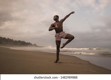 Dramatic Contemporary Dance Choreographer Doing Ballet Beach Workout . Young Attractive And Athletic Afro Black American Man Dancing On Sunrise Doing Performance Rehearsal