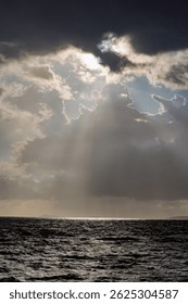 Dramatic Crepuscular Rays Breaking Through Storm Clouds Over Dark Ocean Seascape Thailand