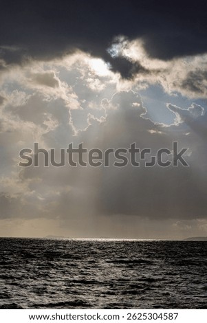 Dramatic Crepuscular Rays Breaking Through Storm Clouds Over Dark Ocean Seascape Thailand