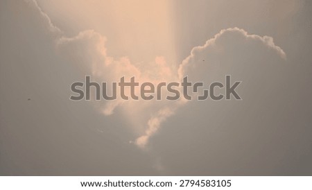Dramatic crepuscular sun rays breaking through dark storm clouds during sunset or sunrise