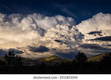 Dramatic cumulonimbus thunderhead storm cloud over the Colorado Wet Mountains lit by the setting sun 