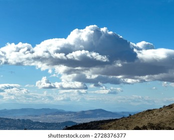 Dramatic cumulus cloud over the Athens basin, panoramic city view from Penteli mountain, Greece. Blue sky