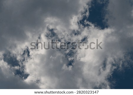 Dramatic cumulus clouds against deep blue sky
