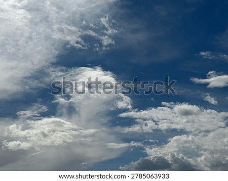 Dramatic cumulus clouds floating across vibrant blue sky creating scenic natural weather atmosphere and peaceful outdoor cloud background