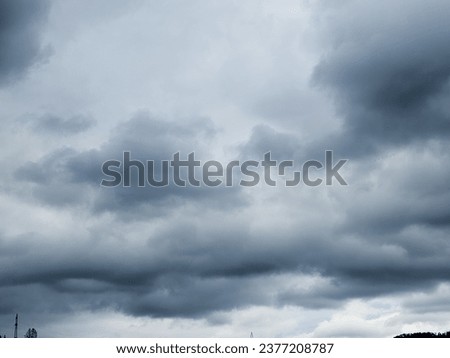 Dramatic cumulus clouds gather in the sky, heralding an impending thunderstorm before the rain. This full-screen panoramic image captures the intensity of nature's display
