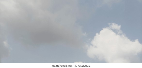 Dramatic cumulus formations drift across a soft blue expanse, capturing the tranquil essence of a transitional atmosphere. Wispy edges of gray vapor contrast against bright, sun-bleached highlights where the hidden light source grazes the upper reaches of the nebulous shapes. The composition emphasizes a sense of vastness and ethereal depth, utilizing a low-angle perspective that invites the viewer to gaze upward into the shifting textures of the heavens. Subtle gradients of pale azure provide a serene backdrop to the denser, charcoal-toned masses, creating a dynamic visual balance between heavy shadow and airy brilliance. This celestial landscape evokes feelings of peace and contemplation, making it an ideal choice for background elements or metaphors for change and clarity.