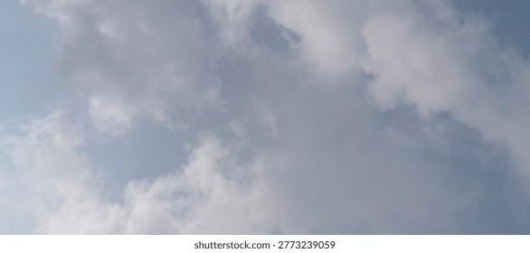 Dramatic cumulus formations drift across a soft blue expanse, capturing the tranquil essence of a transitional atmosphere. Wispy edges of gray vapor contrast against bright, sun-bleached highlights where the hidden light source grazes the upper reaches of the nebulous shapes. The composition emphasizes a sense of vastness and ethereal depth, utilizing a low-angle perspective that invites the viewer to gaze upward into the shifting textures of the heavens. Subtle gradients of pale azure provide a serene backdrop to the denser, charcoal-toned masses, creating a dynamic visual balance between heavy shadow and airy brilliance. This celestial landscape evokes feelings of peace and contemplation, making it an ideal choice for background elements or metaphors for change and clarity.