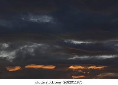 Dramatic Dark Clouds with Golden Light Streaks at Twilight Sky