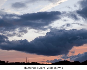 Dramatic Dark Clouds Over Silhouetted Hills at Sunset