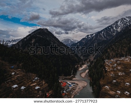 Dramatic dark clouds rolling over Neelum Valley, with the powerful flow of the Neelum River cutting through lush green mountains.