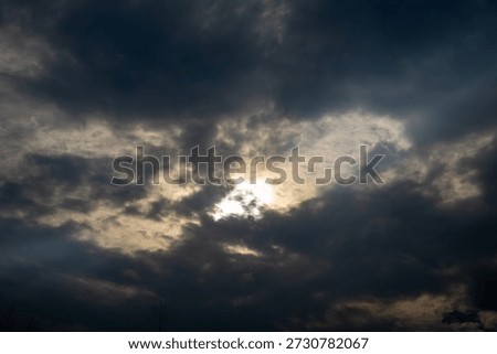 Dramatic dark clouds with sun hiding behind