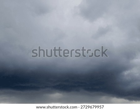 Dramatic dark grey storm clouds covering the sky with an ominous and gloomy atmosphere, suggesting impending heavy rain.