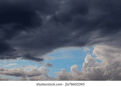 Dramatic dark storm clouds contrasting with patches of blue sky, creating a moody and powerful atmosphere.