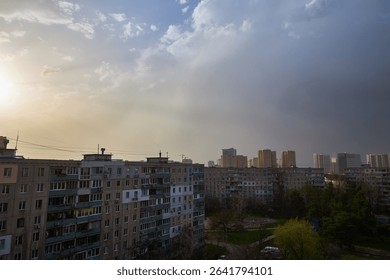 Dramatic dark storm clouds fill the sky over Kyiv, Ukraine, creating an ominous and turbulent atmosphere. A sliver of the silhouetted city is visible below.