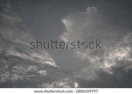Dramatic dark storm clouds forming in a tropical sky before rainfall. The atmospheric cloudscape features dense cloud formations, moody weather conditions, and natural light contrasts, making it suitable for meteorology, climate, weather forecast, environment, and nature-related concepts.