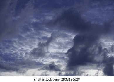 Dramatic dark storm clouds gathering in a deep blue twilight sky.