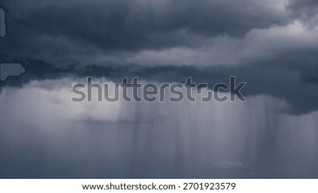 Dramatic dark storm clouds with heavy rain shafts falling. A moody, atmospheric image symbolizing climate change, turmoil, or depression.