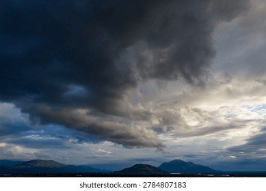Dramatic dark storm clouds rolling over mountains and valley near Chilliwack, British Columbia, Canada, creating a moody atmosphere.