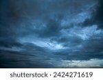 Dramatic dark storm rain clouds black sky background. Dark thunderstorm clouds rainny atmosphere. Meteorology danger windstorm disasters climate. Dark cloudscape storm disaster gloomy gray cloud sky