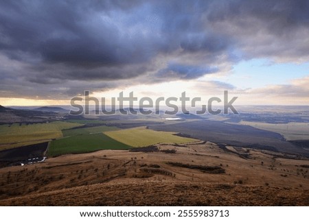 Dramatic dark stormy clouds in sky heaven above Czech Central Mountains landscape far distant view from above, strong wind gale