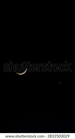 Dramatic deep night sky view with sharp thin crescent moon and planet conjunction in profound darkness